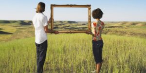 man and woman holding frame in open land