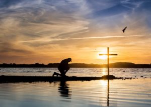 man-kneeling-prayer-cross-water