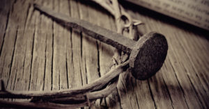 a depiction of the crown of thorns of Jesus Christ, a nail and an old scroll on the Holy Cross