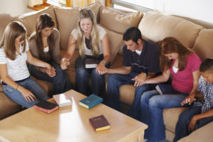 Youth group holding hands and praying